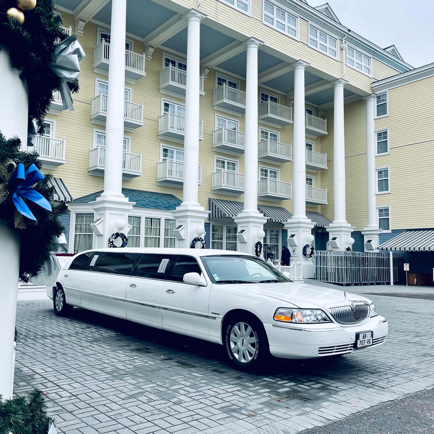 Limousine blanche (style Lincoln) – stationnée devant un bâtiment élégant